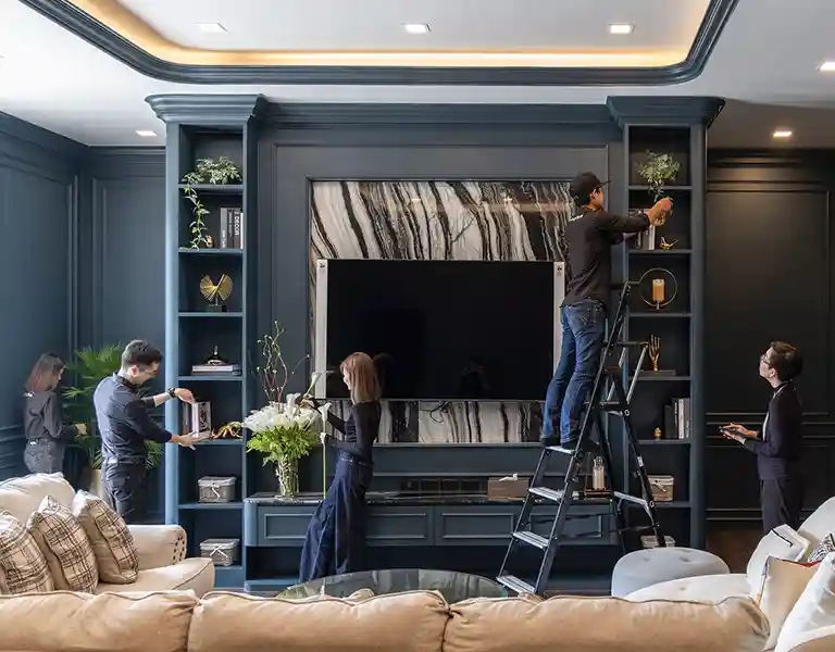 ทีม Homestylist กำลังตกแต่งบ้านและจัดวางเฟอร์นิเจอร์ในห้องนั่งเล่น โดย Livingstyle Studio